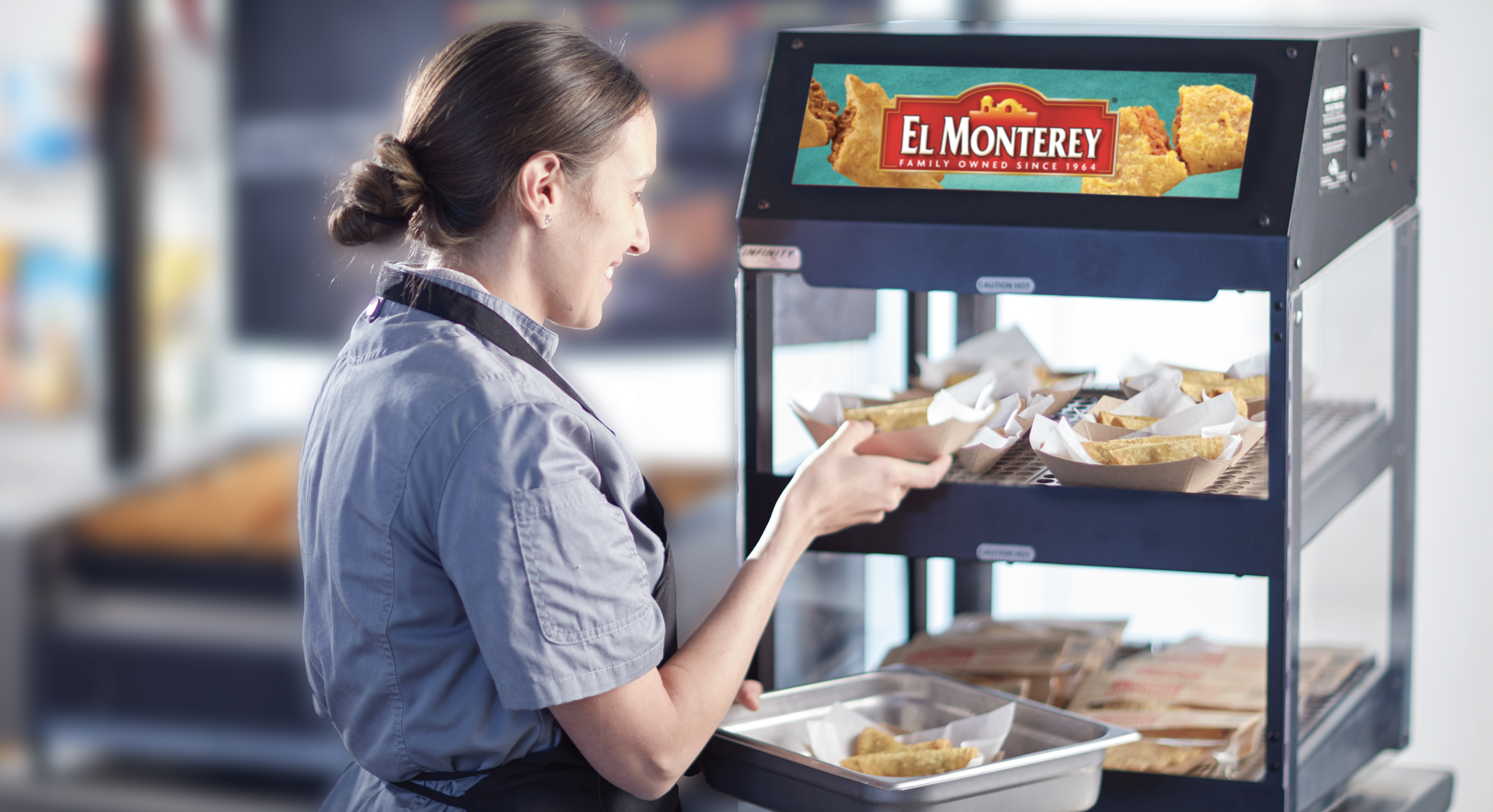 Foodservice operators loading hot case with mini tacos and other El Monterey products