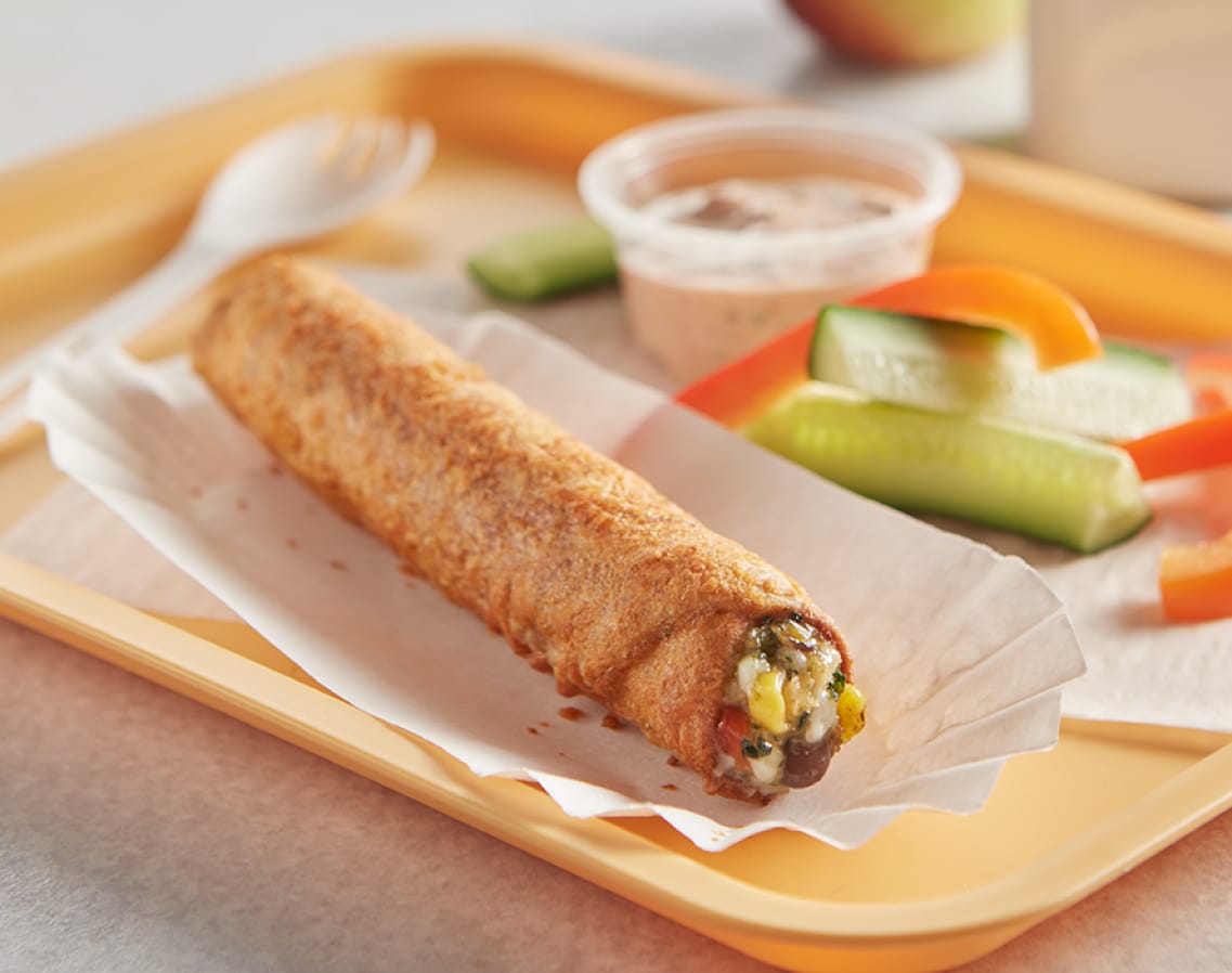 One Southwestern Style Chicken K-12 Tornados on a tray with a few veggies and a container of dip
